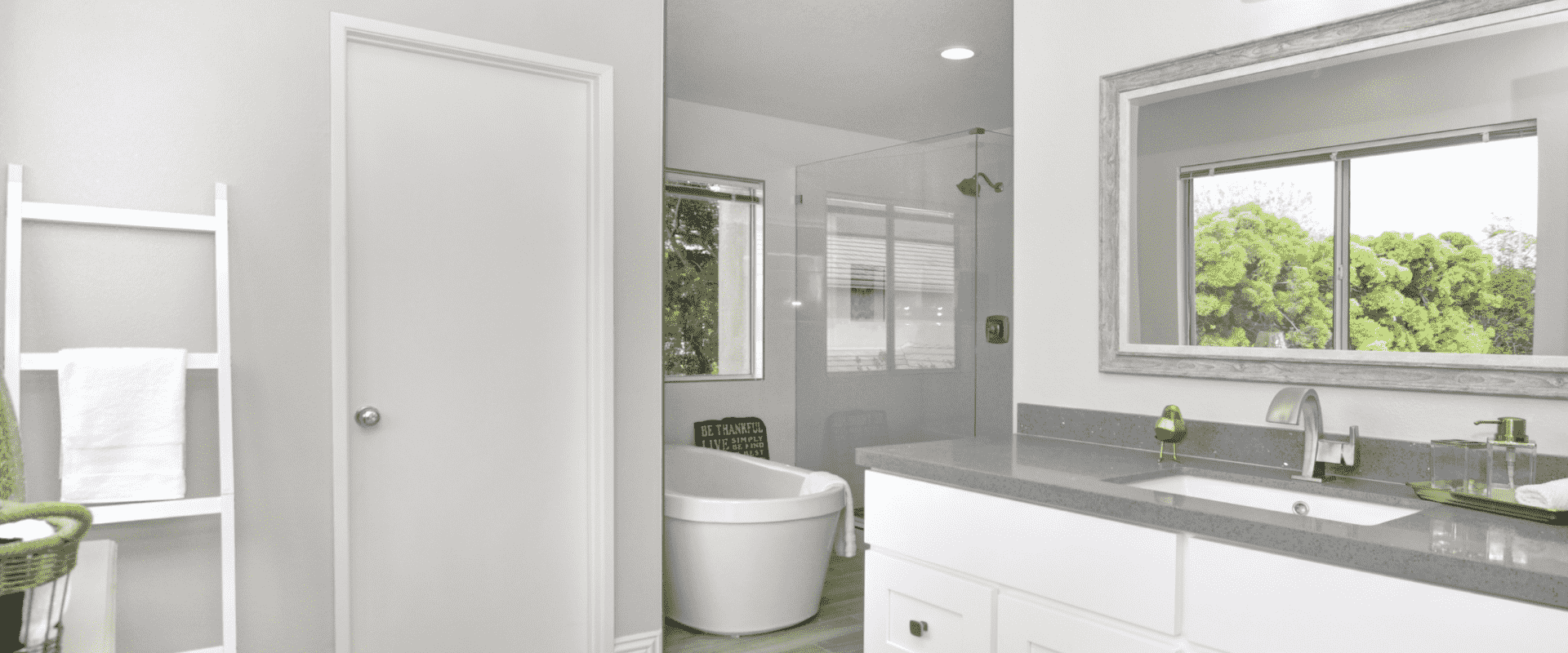 light grey bathroom with a white door and a white countertop with a rectangle mirror