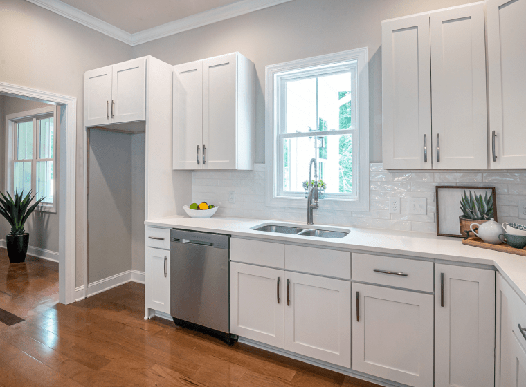 white kitchen with white cabinets and a platinum sink